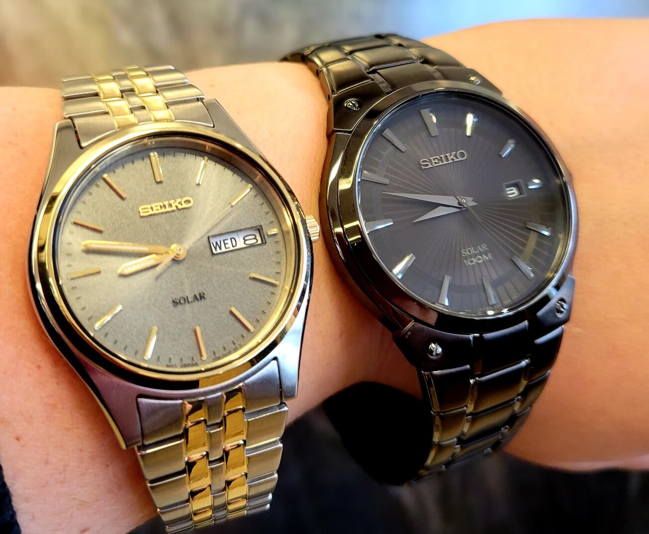 A gold watch next to a black watch