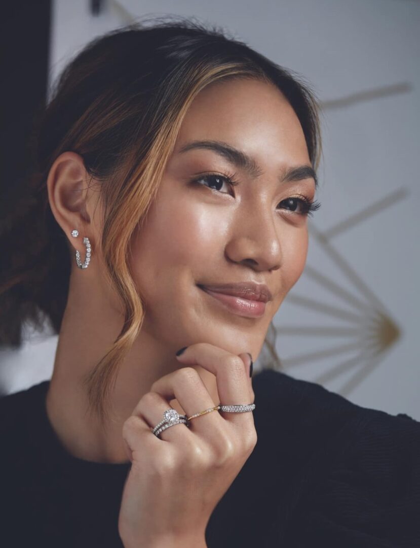 A woman with styled hair and subtle makeup smiles softly.