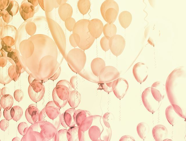 Soft pastel balloons floating against a light background.