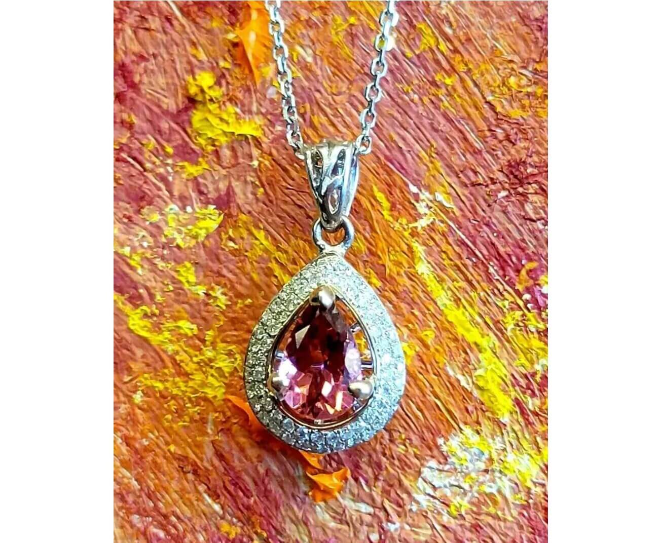 A silver necklace with a red pendant