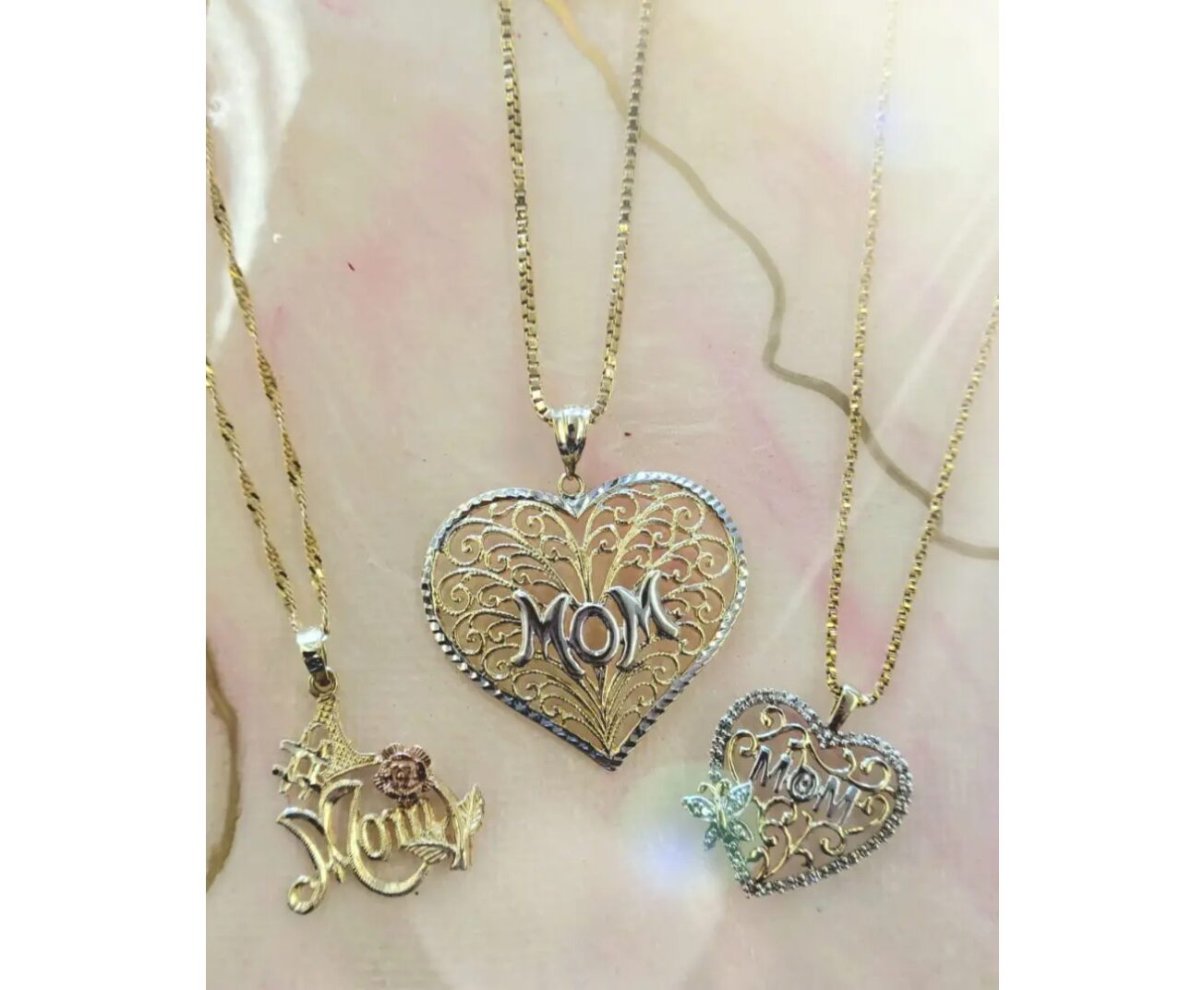 Three necklaces engraved with the word “Mom”